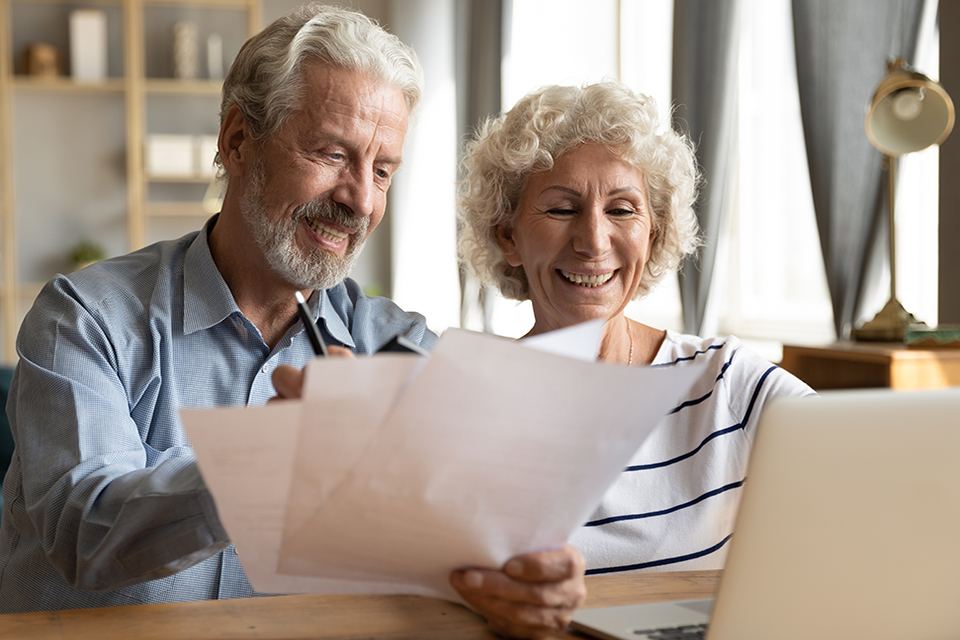 Senior couple use online banking on laptop planning family budget